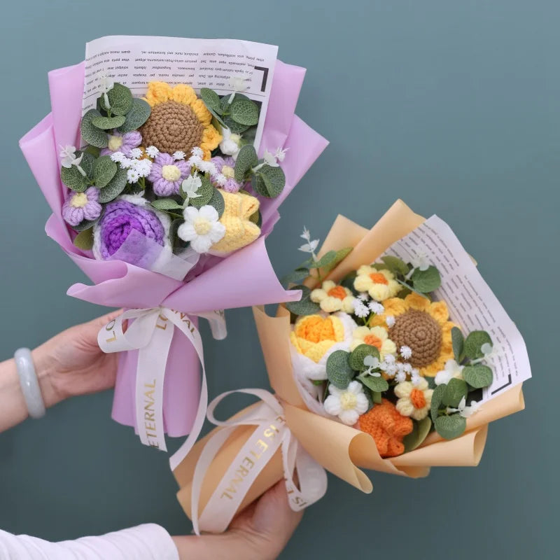 A handmade sunflower crochet bouquet in shades of yellow, purple, and green flowers wrapped in pink paper.