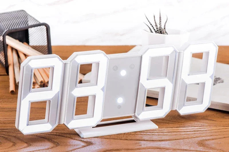 A white 3D LED digital alarm clock displaying the time 8869 on a wooden surface.