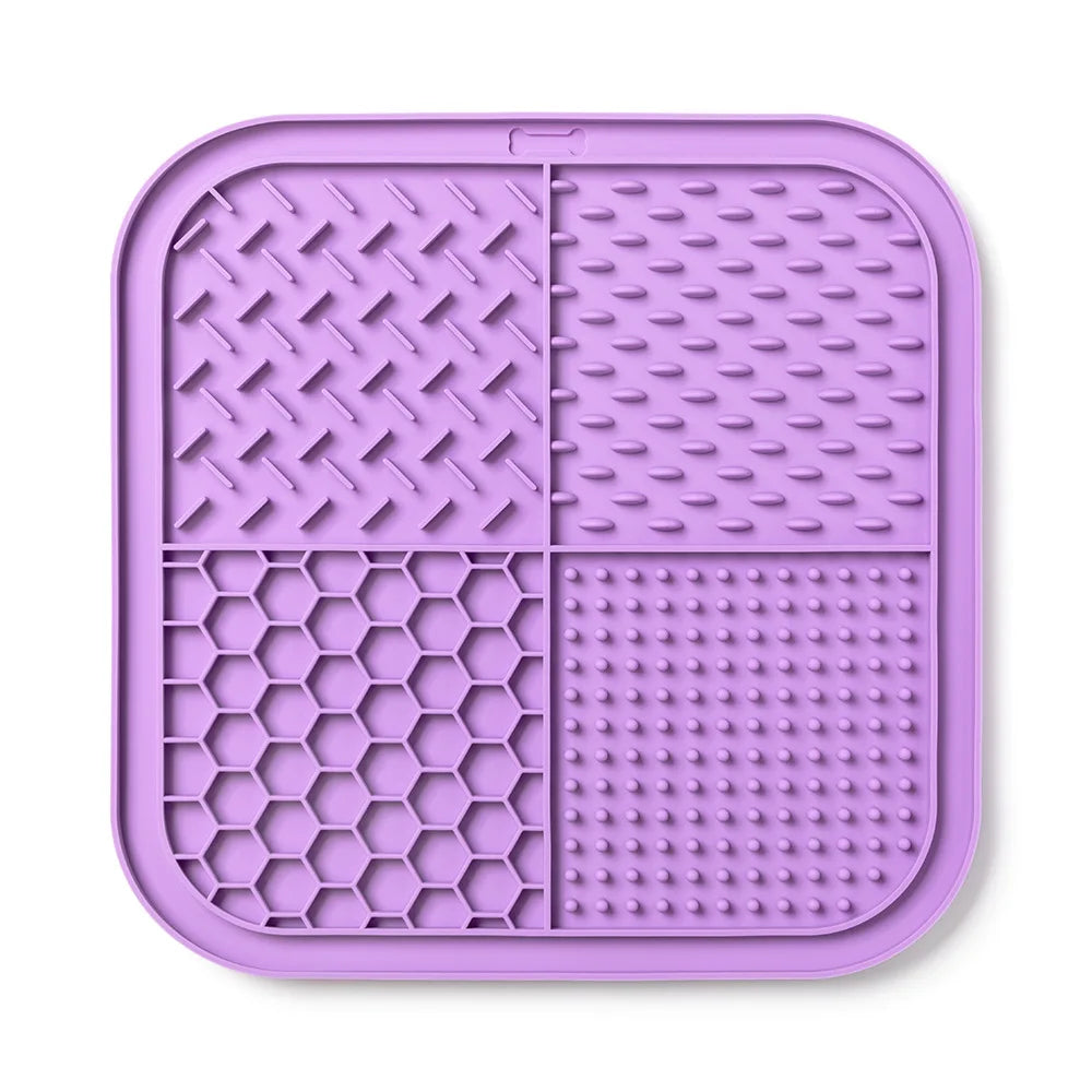 A purple silicone lick mat divided into four sections with various textures for pets