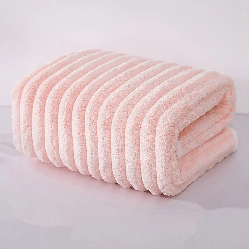 Gerolltes rosa Korallenvelourshandtuch, das seine weiche Textur und Falten zeigt.