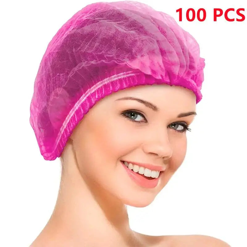 A close-up of a woman wearing a pink disposable bouffant hair net cover.