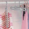 A rack of pink and white clothes hangers, including a silver bar hanger, hanging in a closet.