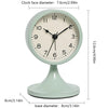 A light mint green round alarm clock with a black face and silver hands, shown with its base dimensions.
