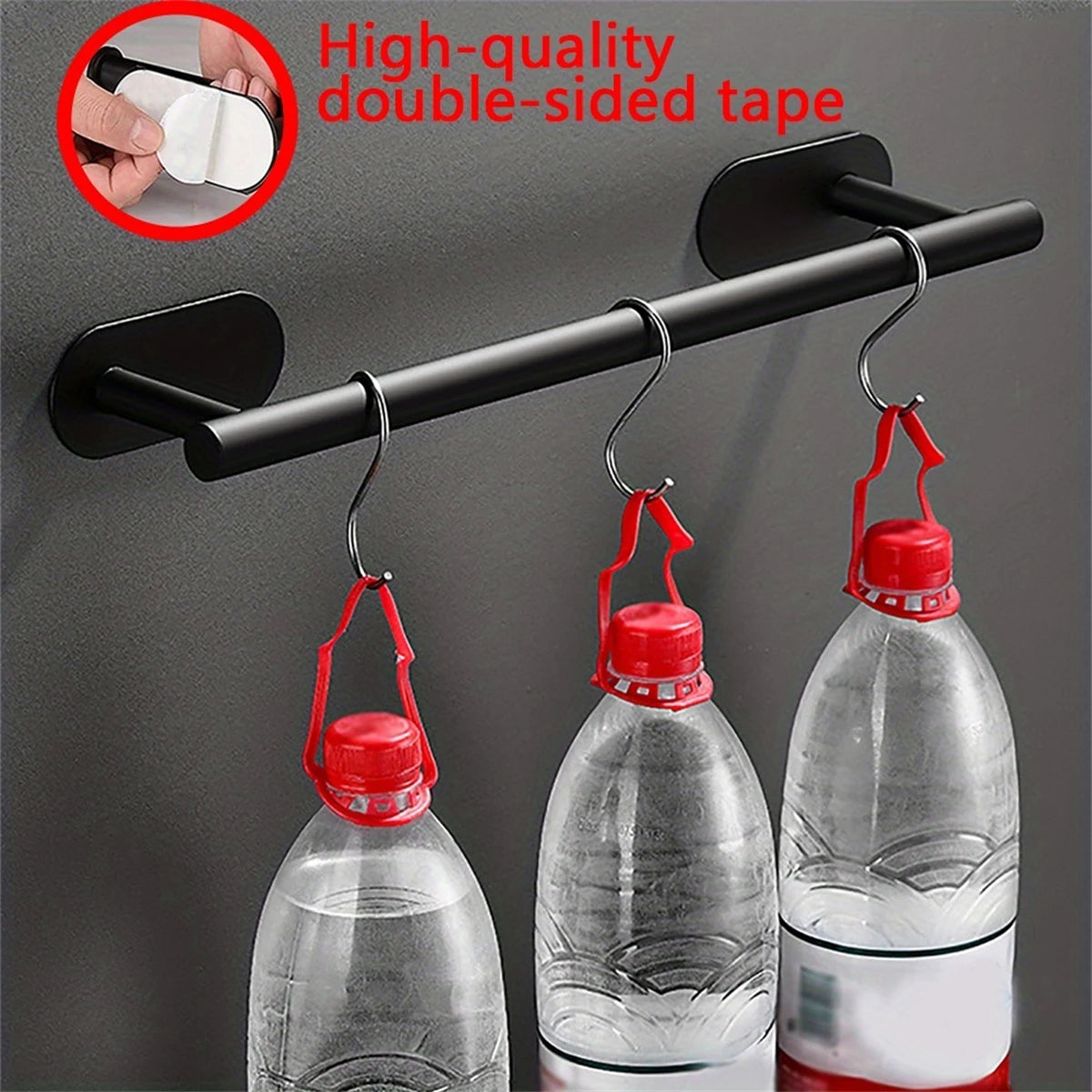 Estante adhesivo de toallas de acero inoxidable negro montado en la pared, sosteniendo tres botellas de plástico transparente