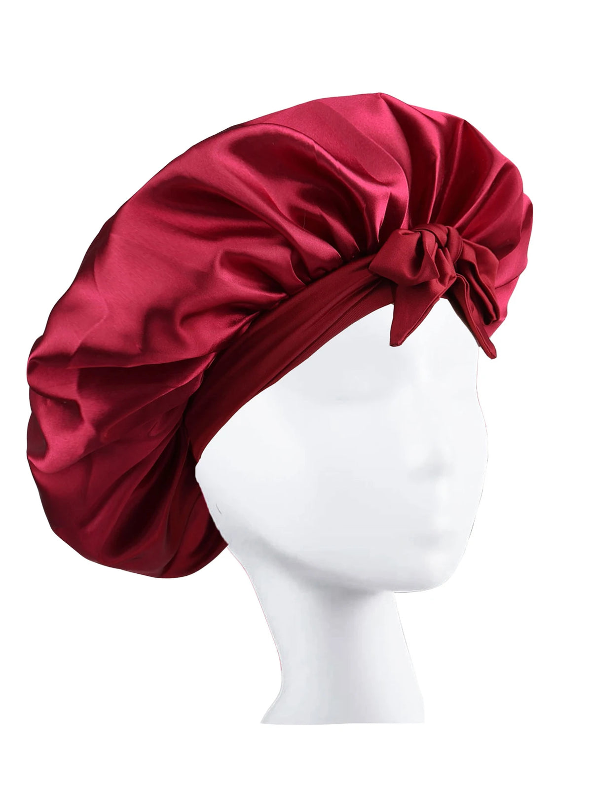 A deep red silky satin sleep bonnet tied in a bow displayed on a white mannequin head.