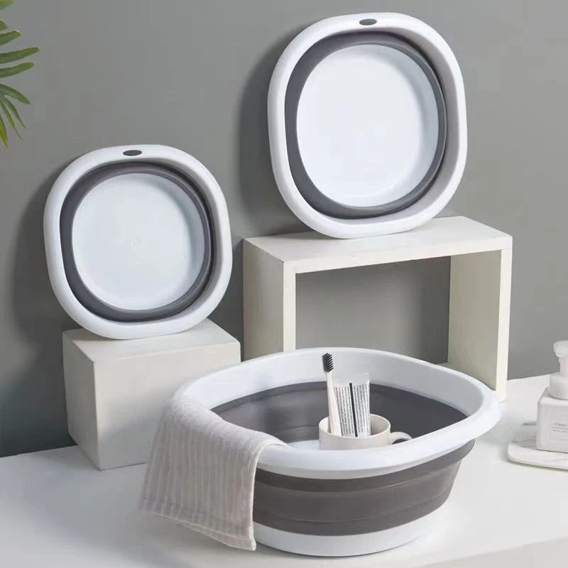 A set of white and gray foldable plastic wash basins or bowls for laundry and camping.