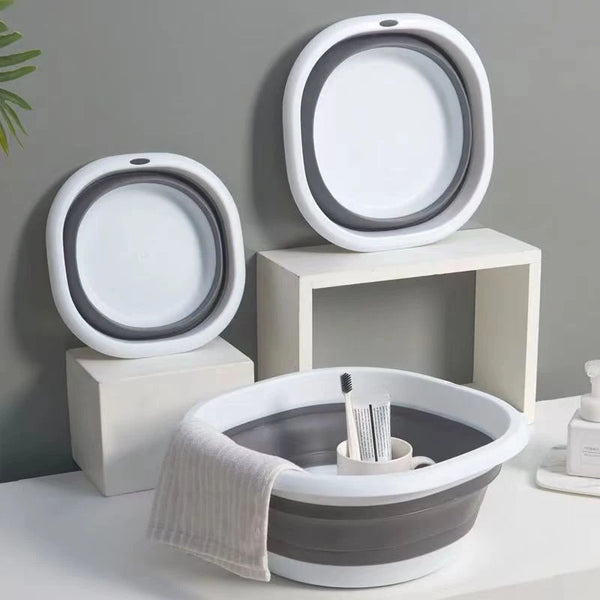 A set of white and gray foldable plastic wash basins or bowls for laundry and camping.