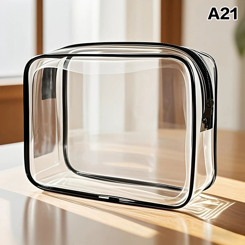 A clear, rectangular cosmetic and storage pouch with a black zipper is shown on a wooden surface.