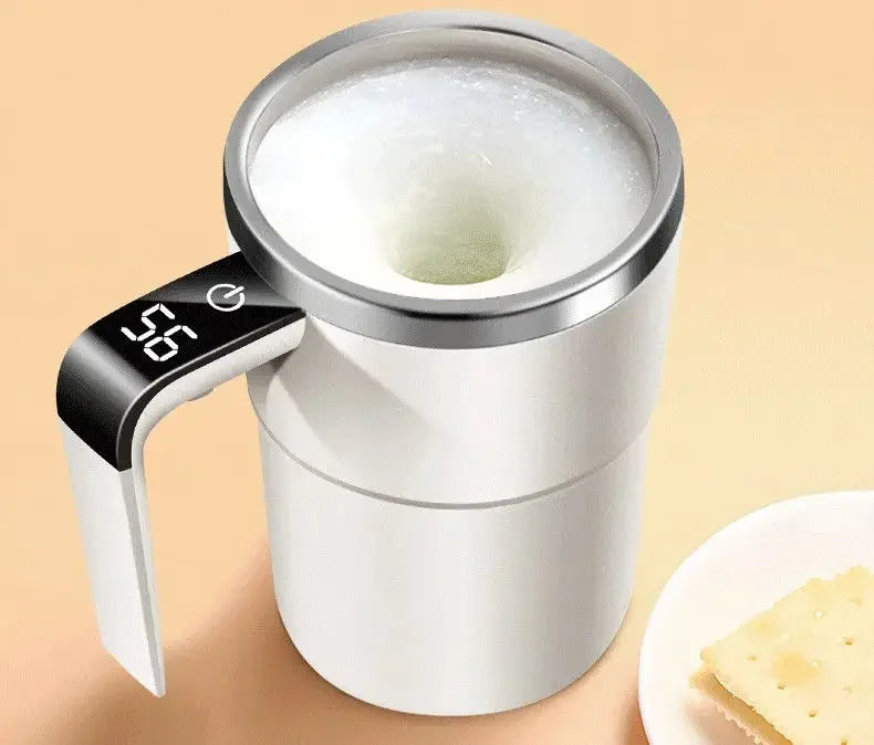 A silver electric self-stirring coffee mug with a black stirring stick is shown next to a plate of cheese.