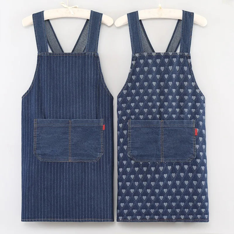 A pair of dark blue striped denim aprons hanging on a hanger.