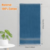 A dark blue 100% cotton bath towel hanging vertically against a light gray wall.
