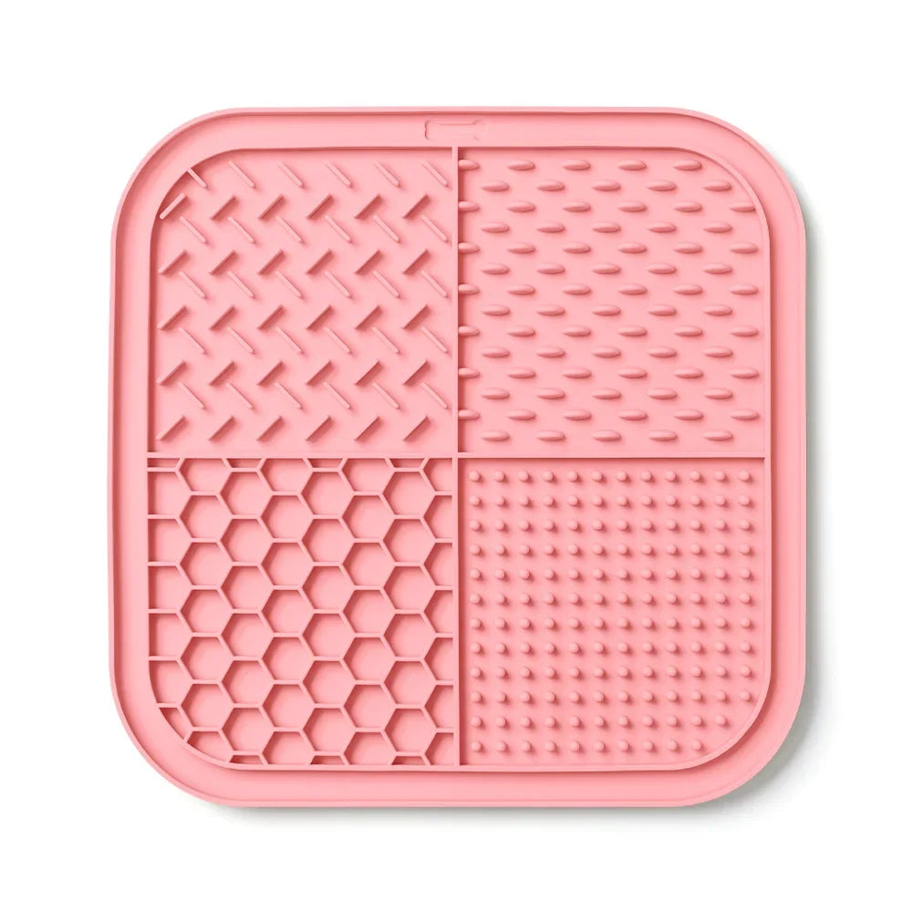 A pink silicone lick mat divided into four sections with various textures for pets