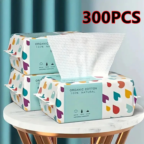 A box of 300 disposable organic cotton facial wipes with colorful packaging displayed on a white table.