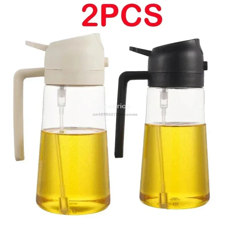 Two clear glass oil spray bottles with black and white tops containing yellow cooking oil.