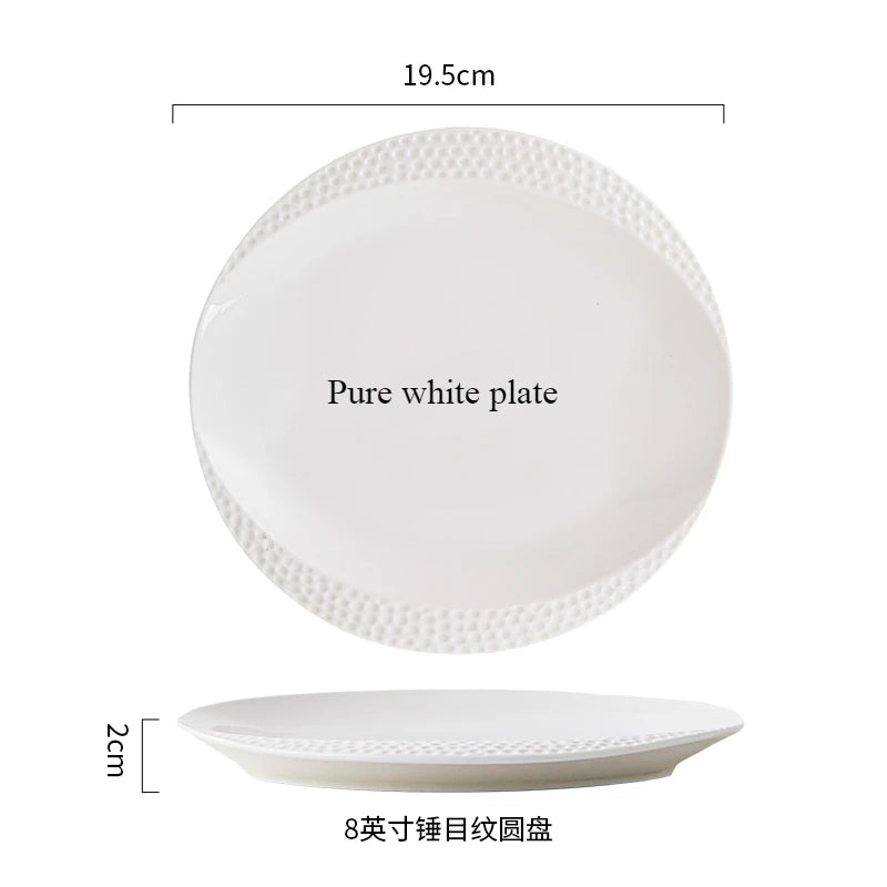 A pure white plate and a shallow white bowl with a decorative rim.