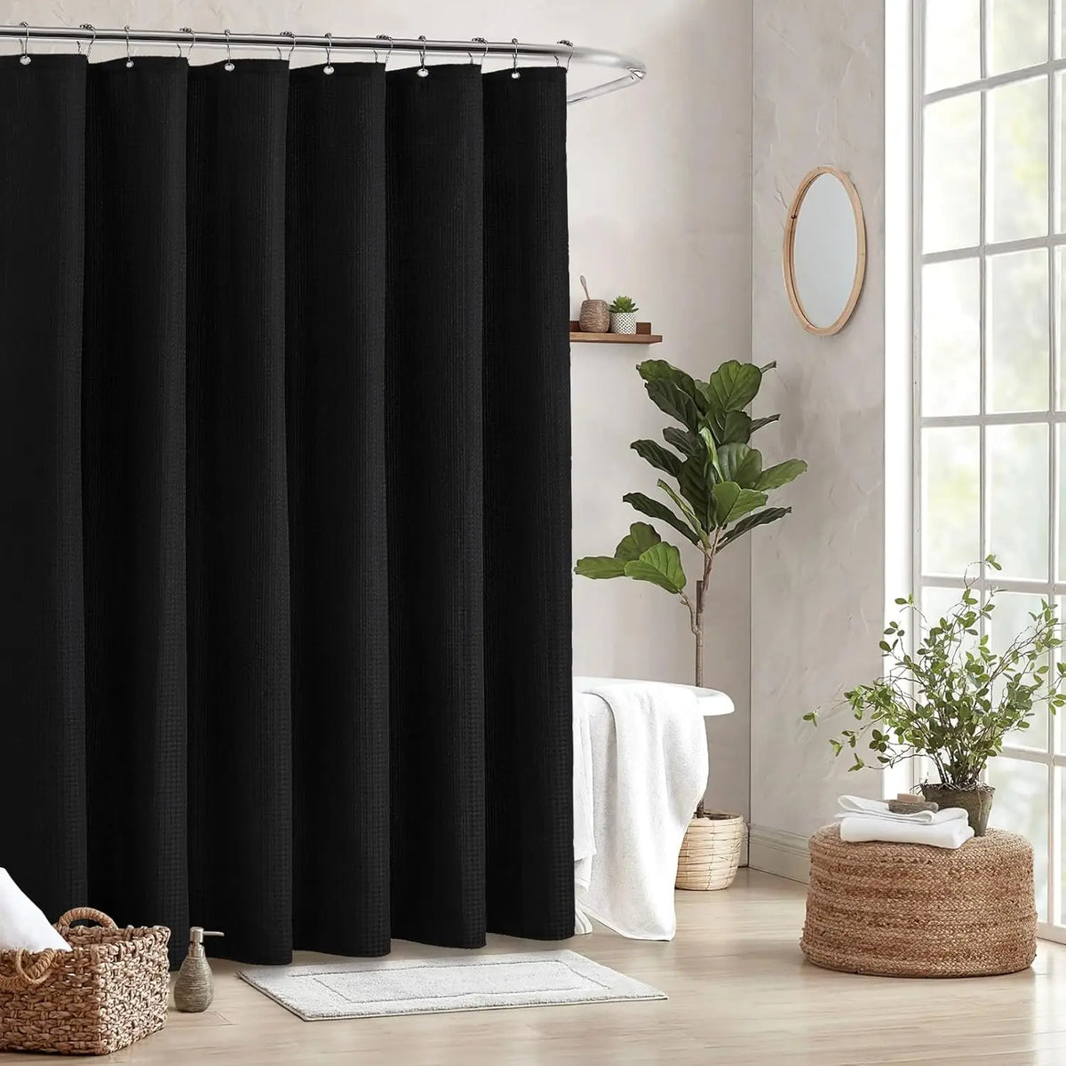 Black heavy-duty waffle weave shower curtain hanging on a metal rod in a bright bathroom setting.