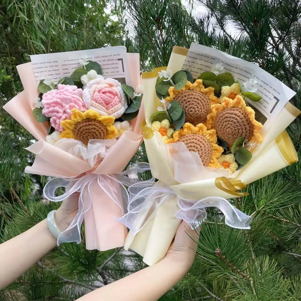 A handmade bouquet of crochet sunflowers in pink and yellow flowers wrapped in sheer paper