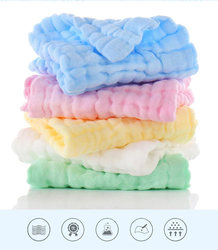 Una pila de cinco toallitas húmedas orgánicas de algodón para bebé y cara en varios colores pastel, incluyendo azul, rosa, am