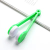 A pair of green plastic tweezers with white microfiber cleaning brushes for eyeglasses.