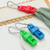 A set of durable glove clips in red and green plastic with metal clasps resting on a white plate.