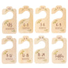 A set of wooden baby closet dividers showing age milestones from newborn to toddler.
