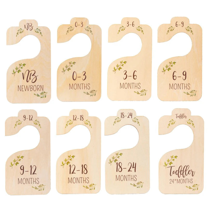 A set of wooden baby closet dividers showing age milestones from newborn to toddler.