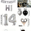 Un set de globos con números, formas de corazón y una guirnalda de papel metálico plateado y negro.