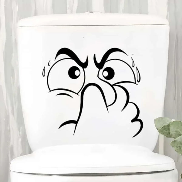 White toilet lid featuring a black cartoon face with wide eyes and a raised hand.