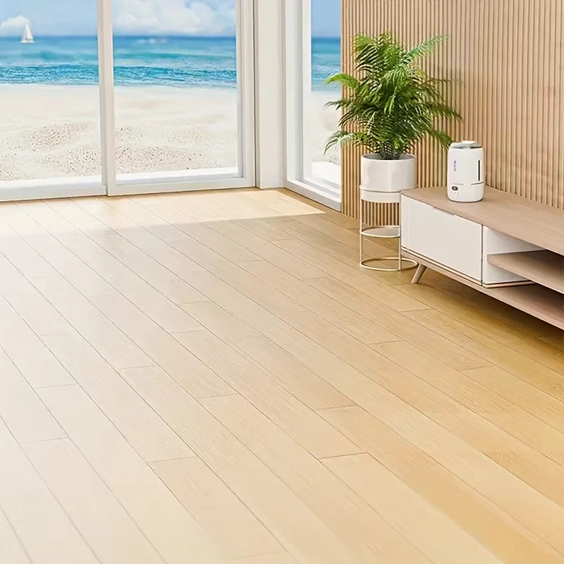 Suelo de madera clara con grandes ventanas que ofrecen vistas a la playa y el océano