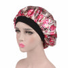 A woman models a floral print satin sleep bonnet with a black elastic band.