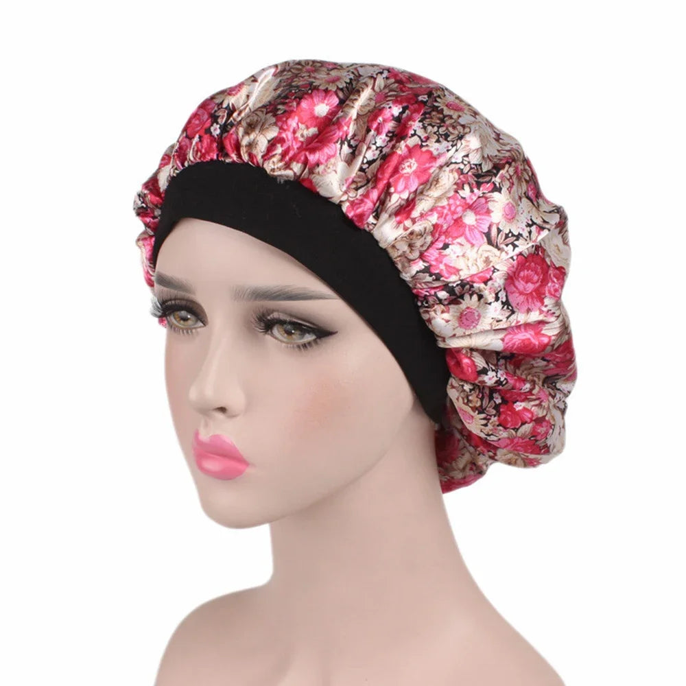 A woman models a floral print satin sleep bonnet with a black elastic band.