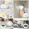 A hand is using a 5-in-1 electric spin scrubber with replaceable brush heads to clean a shower glass.