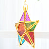 A golden forged iron star hanging candlestick with multicolored stained glass panels.