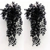 A pair of black artificial flower garlands with dark green leaves and thin stems hanging down.