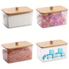 A set of bamboo lidded containers holding various types of dryer sheets and bath salts.