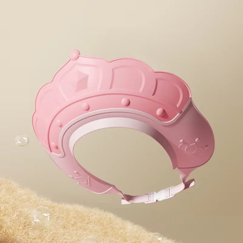 A pink adjustable baby bath shampoo shield cap is shown against a light background.