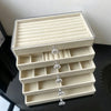 A light beige 5-tier desktop jewelry organizer rack with clear acrylic compartments.