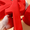 A hand holds a red silicone number cake mold, showing the texture and shape of the mold.