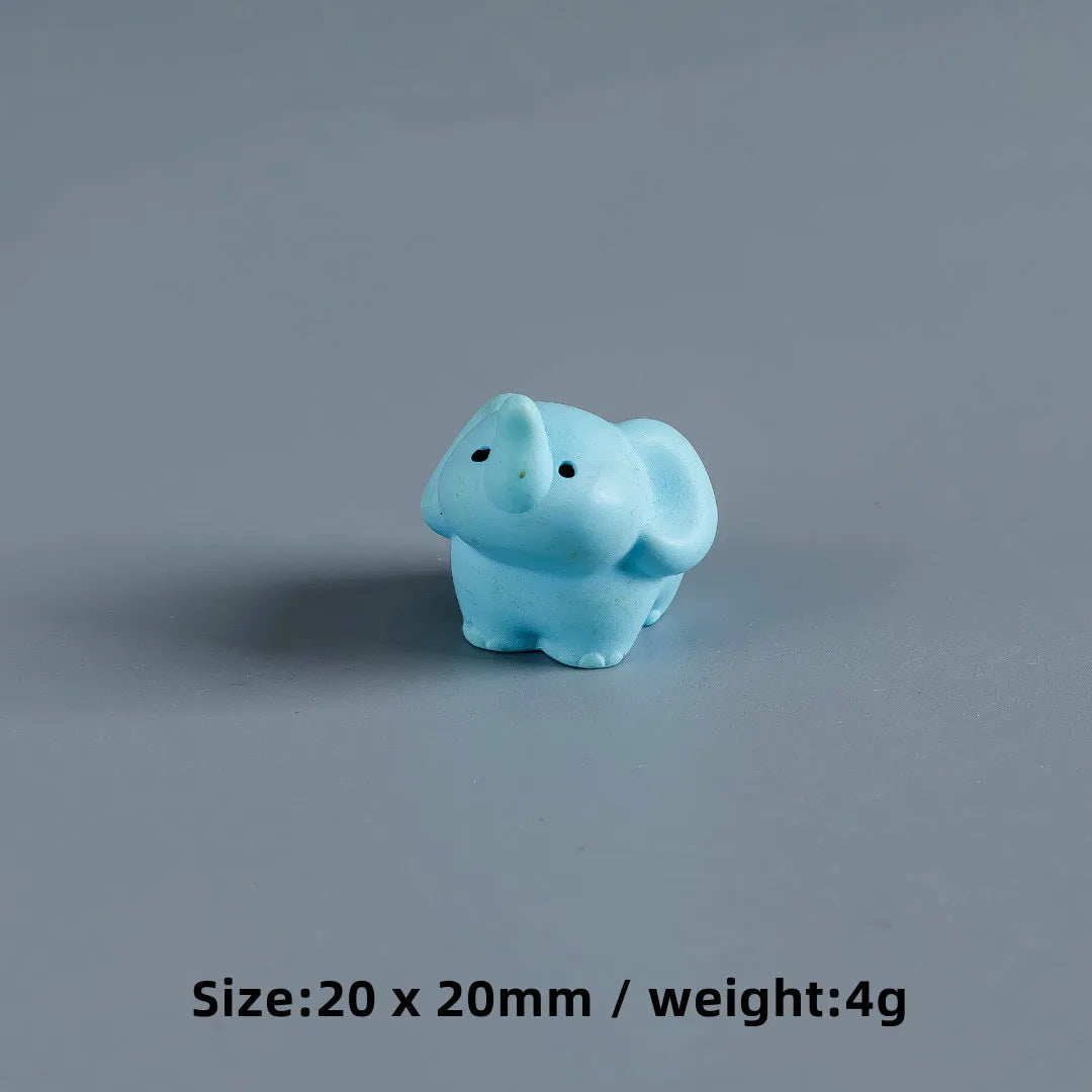 A small, light blue resin figurine shaped like a baby elephant.