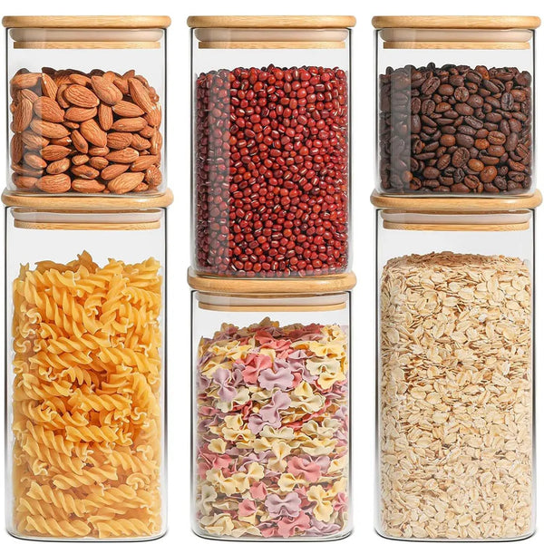 A collection of various dried foods including almonds, red beans, and pasta stored in clear glass canisters.