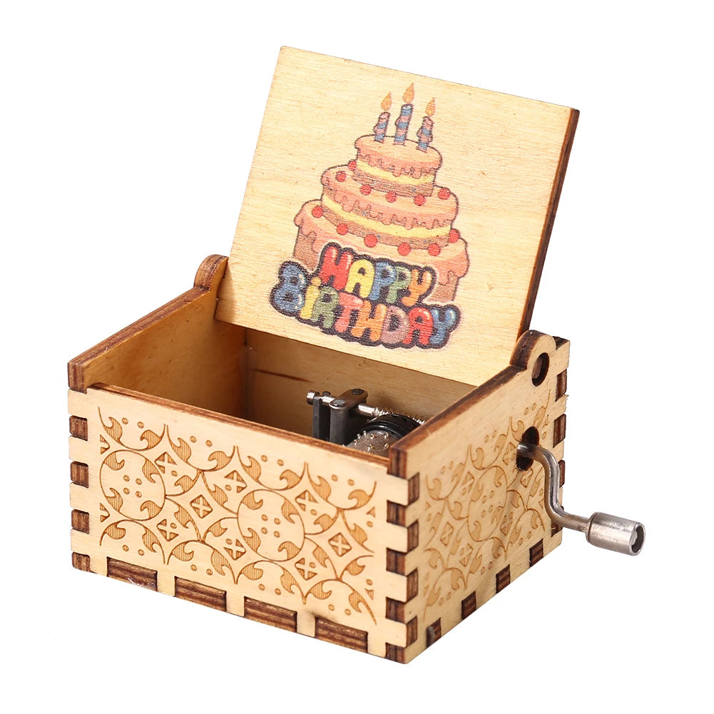 A hand-cranked wooden music box with a lid showing a birthday candle design.
