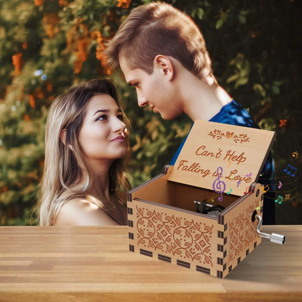 A young couple looks at a vintage engraved wooden music box with a lid open on a wooden table.
