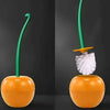 A decorative cherry-shaped toilet brush set with a green handle and orange base.