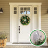 White door with a wreath decoration and clear suction cup hooks visible on the door frame.