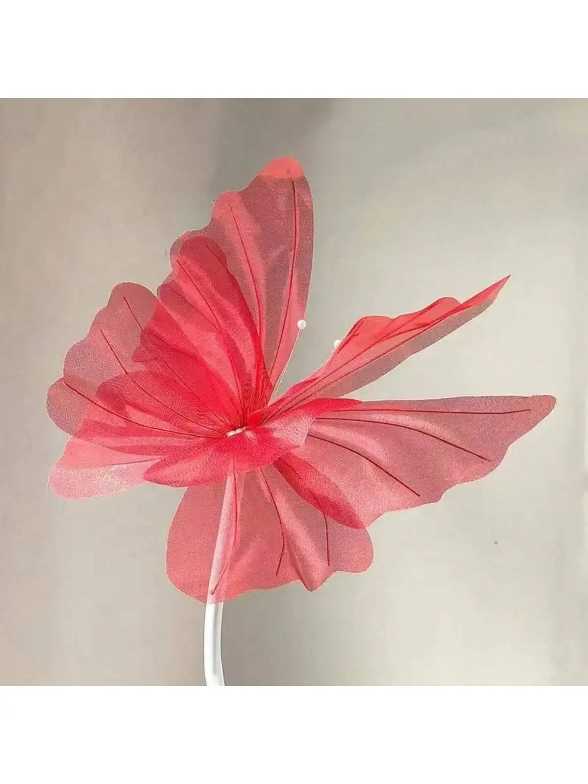 A vibrant pink and red 3D simulated butterfly decoration with delicate, layered wings.
