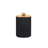 A black cylindrical organizer with vertical ridges and a wooden ball on top.