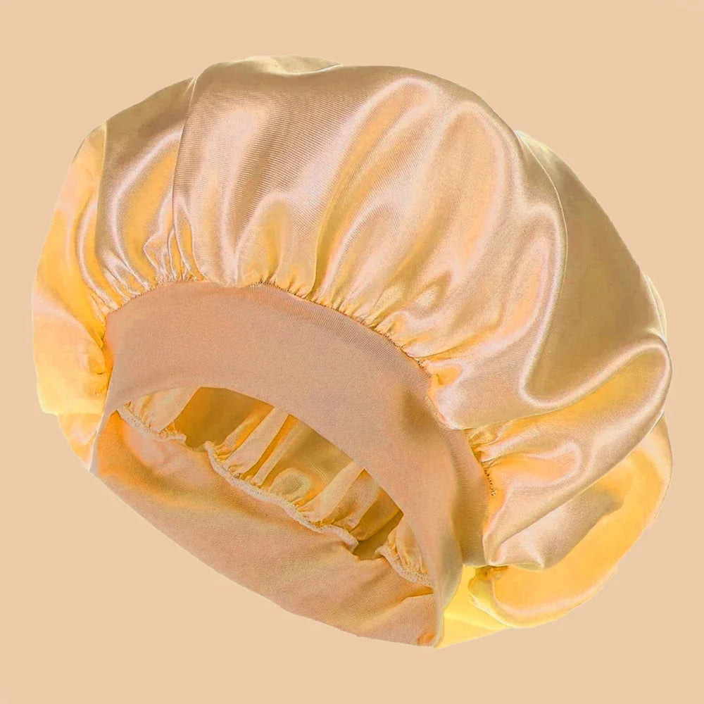 A solid satin wide brim shower cap in a pale yellow color shown from above.