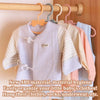 A display of baby clothing items, including a light gray vest and striped shirt, hanging on wooden hangers.
