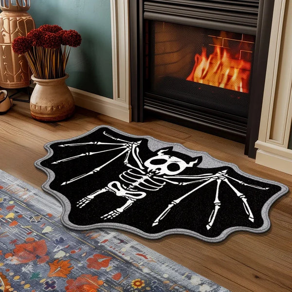 A black decorative rug shaped like a bat with skeletal wings and skull, placed on a wooden floor.