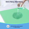 Une main verse de l'eau sur un tampon vert absorbant, démontrant une absorption accrue.